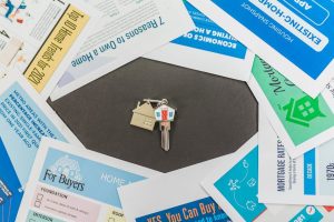 Australian housing market: Labour government policy & real estate brochures, house key.