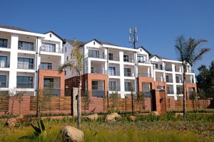 Australian property crisis: apartment complex with garden, white facade, red brick.