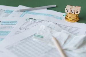 호주 세금 개혁: 세금 서류 더미와 코인, 세금 환급의 상징